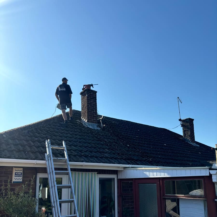 A roofer working across a newly tiled roof