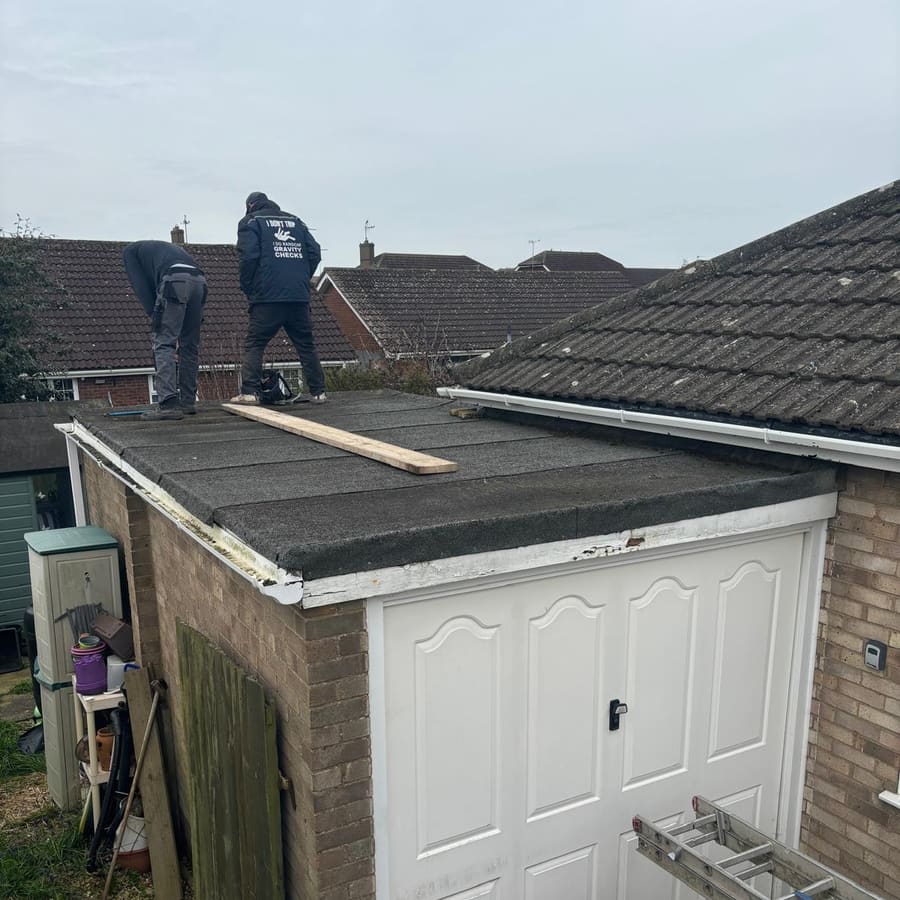 Roofers stripping an old garage flat roof