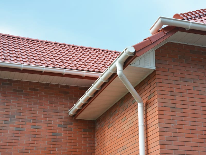 New white guttering on a tiled roof edge
