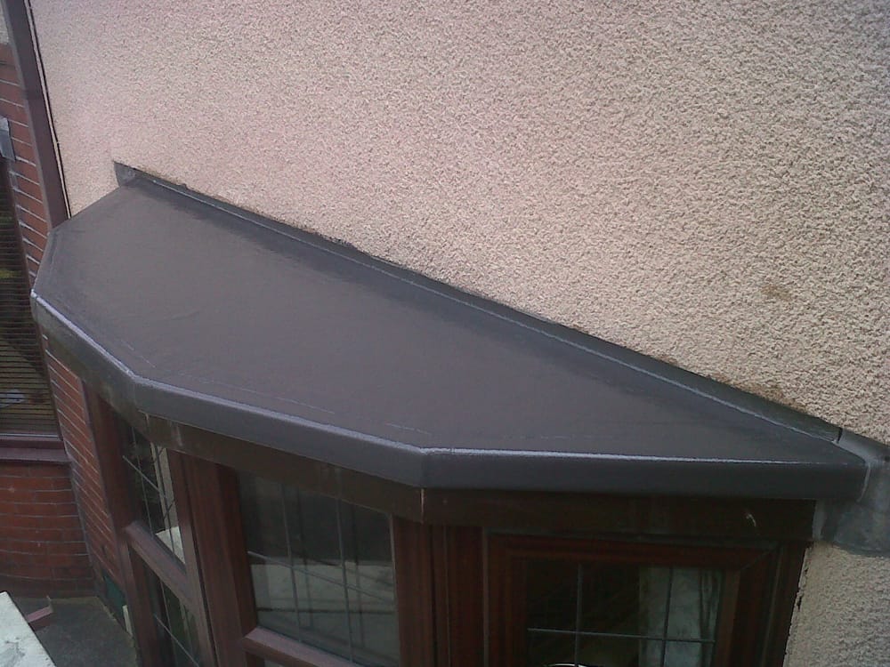 A finished grey GRP fibreglass flat roof over a bay window