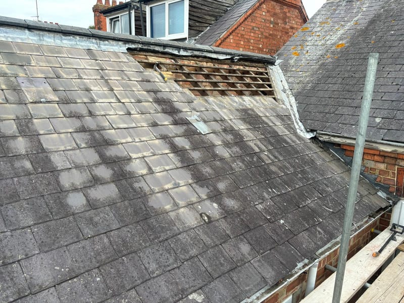An old, worn tiled roof before repair